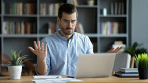 Image of a person looking at his laptop with a confused expression implying he is dealing with compatibility issues of his security system with NBN